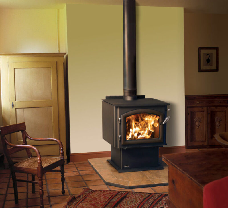 3100 Millennium standard wood stove by Quadra-Fire against a tan wall of a living room with hearth pad