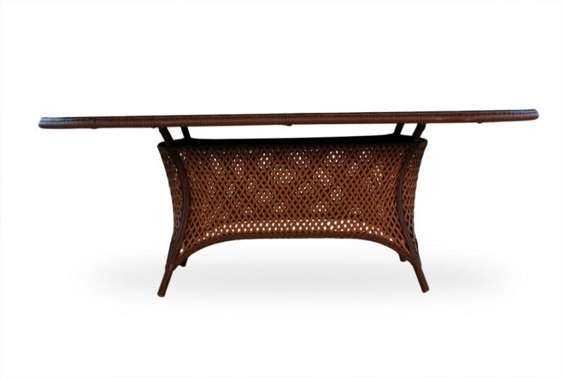 An elegant wooden table with a detailed, woven rattan undercarriage and a smooth, long tabletop featuring an integrated stove, isolated on a white background.