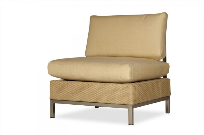 A modern outdoor lounge chair with a light tan cushion on a woven beige base and metallic legs, isolated on a white background, positioned near an insert fireplace.