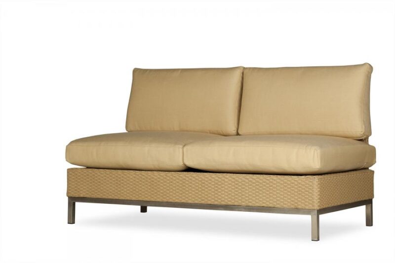 Beige outdoor sofa with a metal frame and woven detailing, featuring two plush cushions on the seat and back. The background is a plain light color with a fire pit insert.