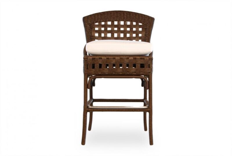 A wicker dining chair with a high, patterned backrest and a light cushion on the seat, isolated against a white background near a fireplace.