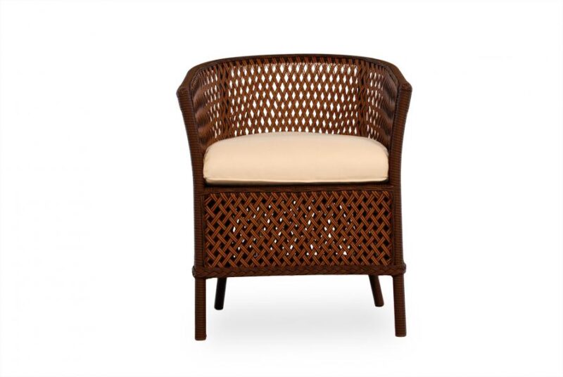 A traditional wicker armchair with a dark brown finish and a beige cushion, isolated on a white background near a fireplace.