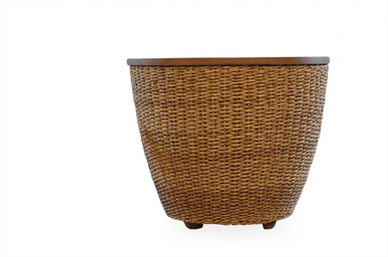 A wicker planter with a dark brown rim and tiny wooden legs, isolated on a white background beside a stove.