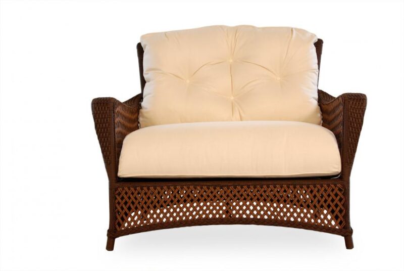 An elegant wicker armchair with plush cream cushions, isolated on a white background, includes a cozy fireplace insert.
