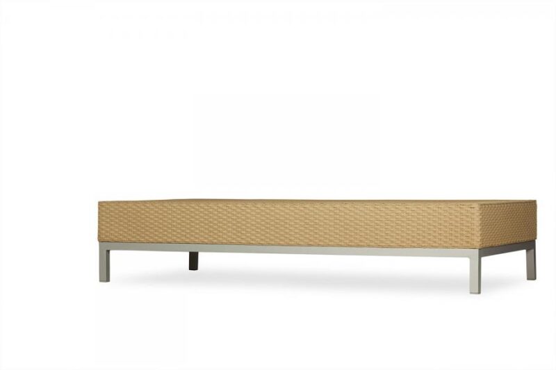 A modern beige daybed with a textured surface and minimalist metal legs isolated on a white background near a fireplace.