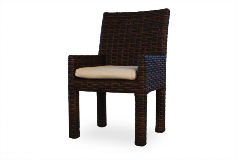 A dark brown wicker chair with straight back and square arms, featuring a beige cushion on the seat, isolated against a white background, ideal for cozying up near a fireplace.