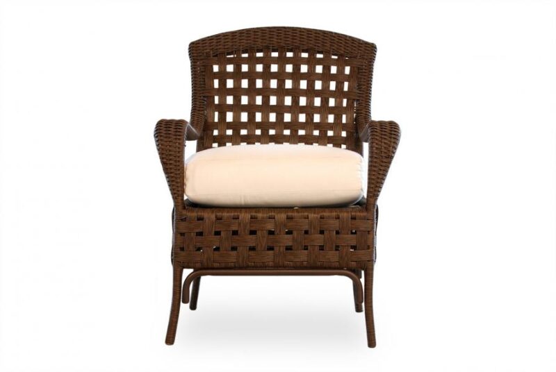 A brown wicker chair with a high back and armrests, featuring a neatly placed beige cushion on the seat, isolated against a white background near a fire pit.