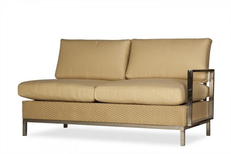 A modern beige sofa with plush cushions and a minimalist metallic frame, featuring wicker side panels and a sleek, contemporary design with a fireplace insert.