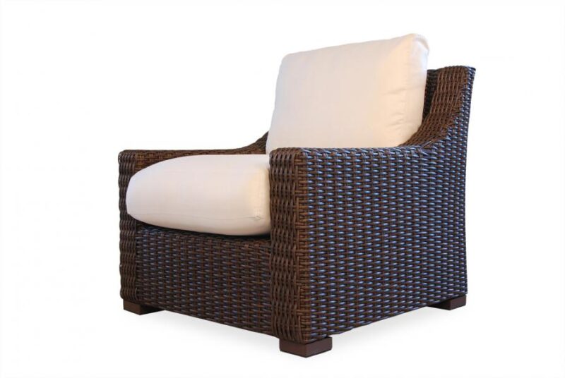 A modern wicker armchair with a dark brown frame and plush white cushions, isolated on a white background near a fire pit.