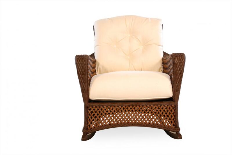 An elegant cream-colored upholstered armchair with tufted back cushion and brown woven rattan sides, isolated on a white background, perfect to insert by the fireplace.