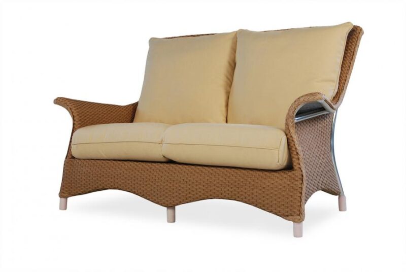 A modern two-seater sofa with a wicker frame and plush beige cushions, isolated on a white background, perfect for cozying up near the fireplace.