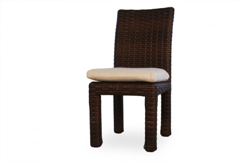 A dark brown wicker dining chair with a light beige cushion on the seat, isolated near a fire pit on a white background.