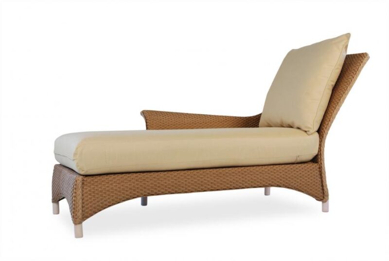 A stylish wicker chaise lounge with a plush beige cushion and matching headrest pillow, isolated on a white background, complemented by a cozy fireplace insert.
