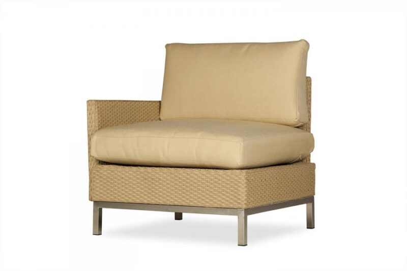 A single beige cushioned armless chair with a textured wicker body and metallic legs, next to a fire pit, isolated on a white background.