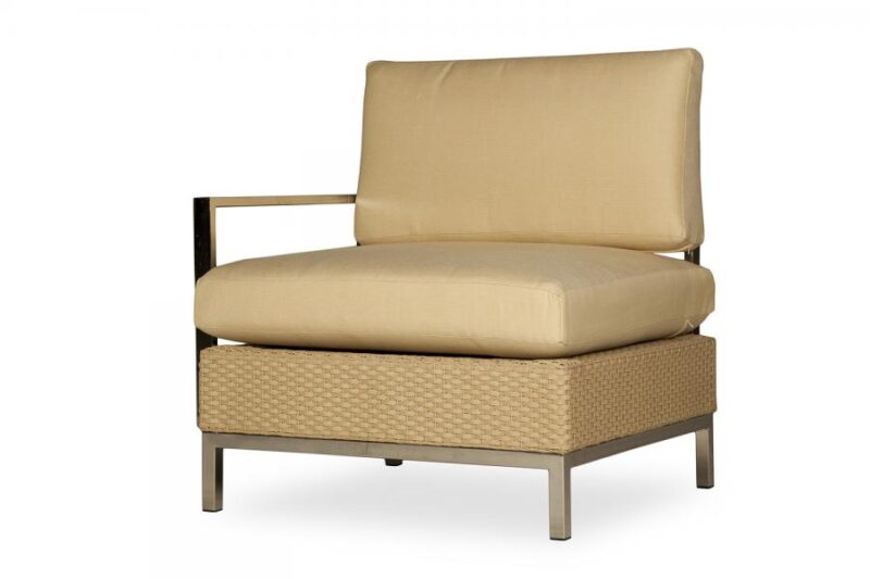 A modern outdoor armchair with a beige cushion on a woven tan base and a sleek metal frame, isolated on a white background next to an elegant fire pit.