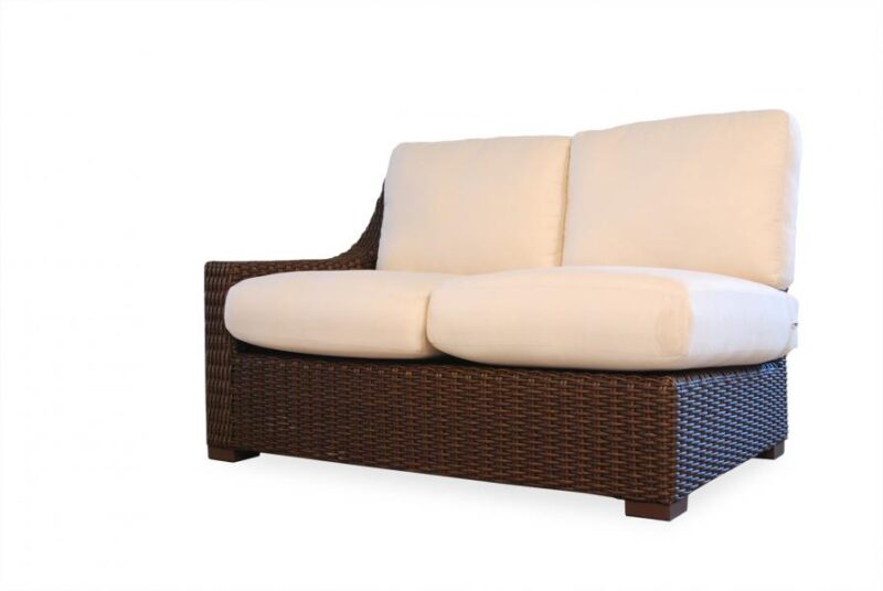 A modern brown wicker loveseat featuring plush white cushions, isolated on a white background with a fireplace insert.