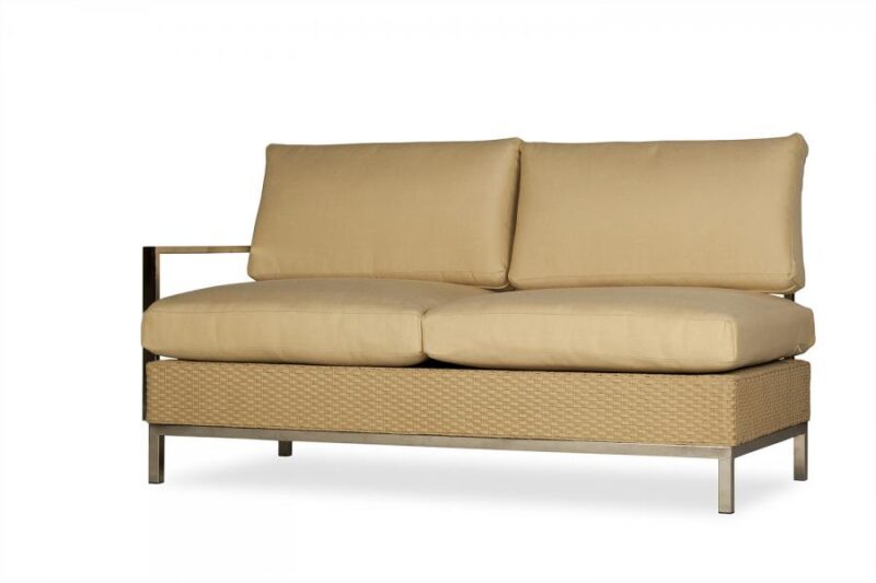 A modern beige two-seater sofa with plush cushions, featuring a wicker base and a minimalistic metal frame, isolated on a white background, near a stove.