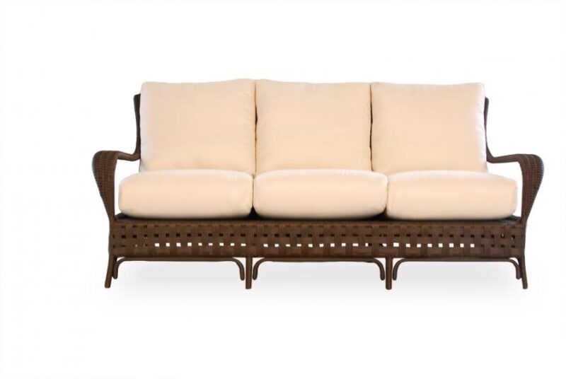 A modern three-seater sofa with beige cushions and a dark brown wicker frame, isolated on a white background, perfect for placing near a fireplace.