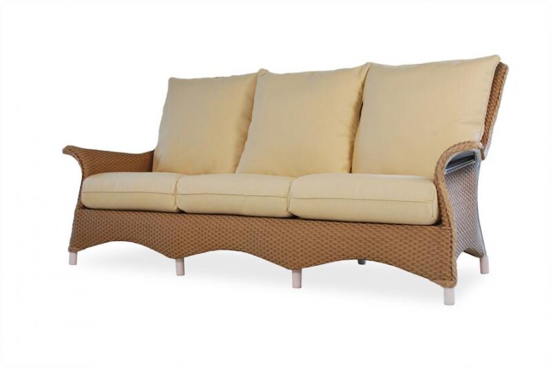A wicker outdoor sofa with beige cushions on a white background. The sofa features a curved design with sleek armrests, raised legs, and is perfect for gathering around a fire pit.