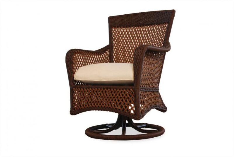 A swivel rattan armchair with a high back and beige cushion, isolated on a white background, perfect by the fireplace.