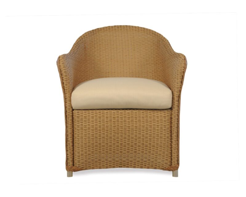 A beige cushioned wicker chair with a high rounded back and wooden legs, presented against a plain white background with a fireplace insert visible in the scene.