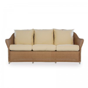A wicker three-seater sofa with a light beige frame and cushions, accompanied by three matching backrest pillows and a nearby fireplace, on a white background.