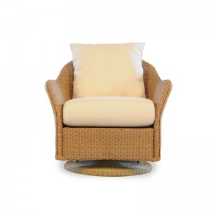 A plush armchair with a wicker body and swivel base, featuring soft cream cushions and a matching pillow, isolated on a white background near a fireplace.