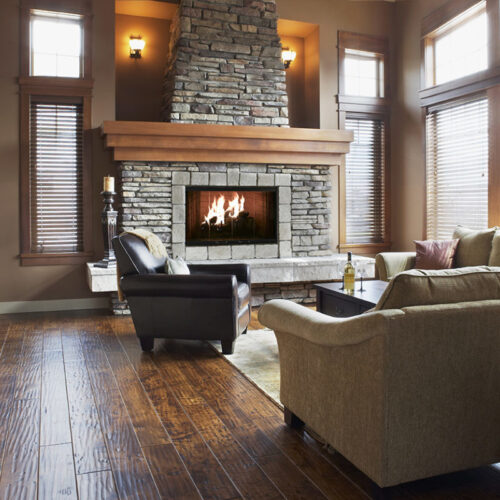 Element wood fireplace by Heatilator with black trim and dark gray stone surround and hearth in rustic living space