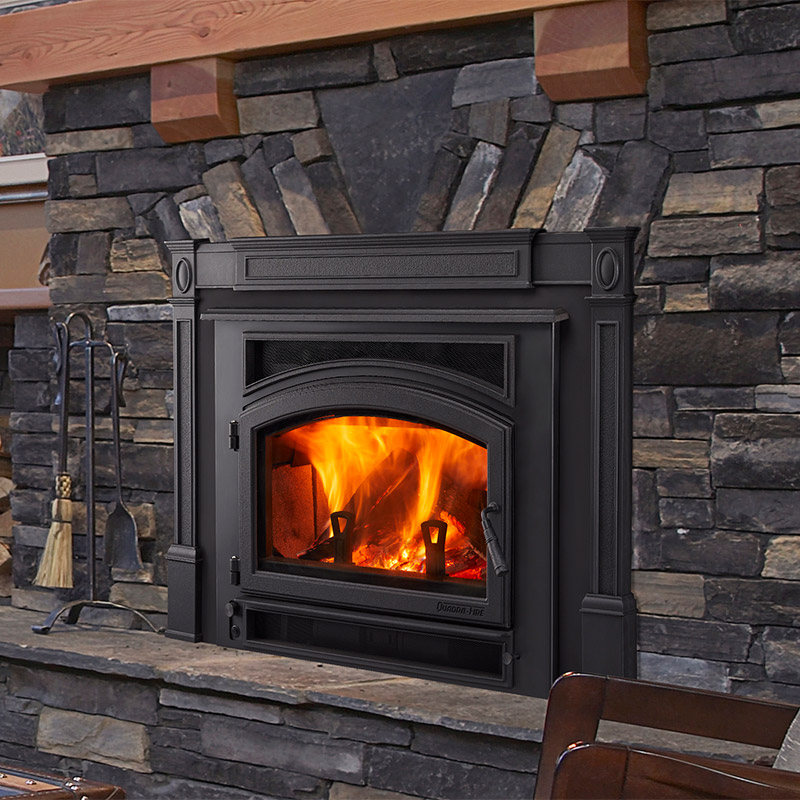 Expedition II wood fireplace insert by Quadra-Fire in Classic Black with cast iron trim and gray stone masonry