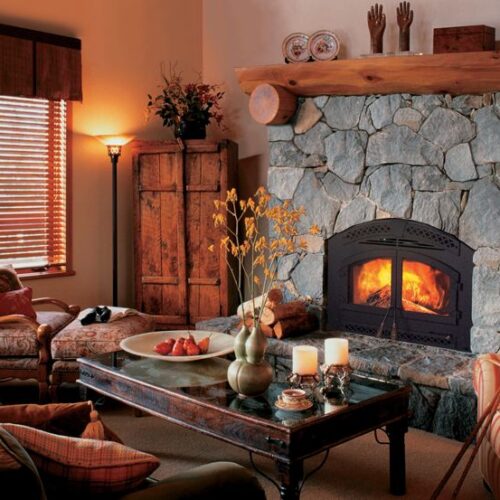 Northstar wood fireplace by Heat & Glo in black with blue stone masonry and hearth in a rustic living room