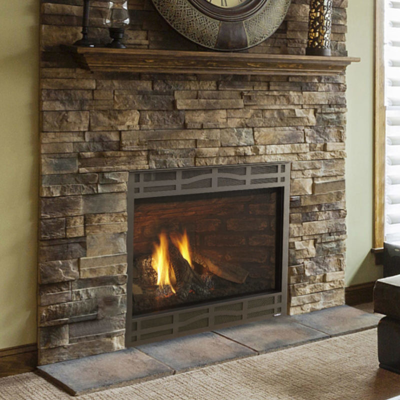 Novus series NXT gas fireplace by Heatilator in bronze with Demi front against a tan stone masonry hearth