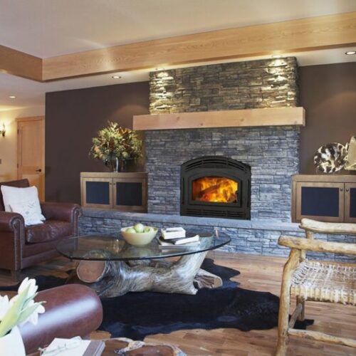 Pioneer II wood fireplace by Quadra-Fire in Classic Black with black arched door against blue stone masonry
