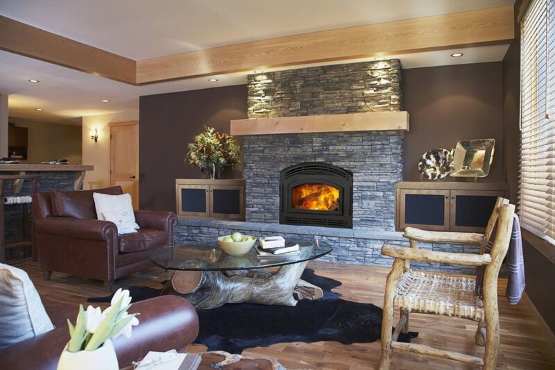 Pioneer II wood fireplace by Quadra-Fire in Classic Black with black arched door against blue stone masonry