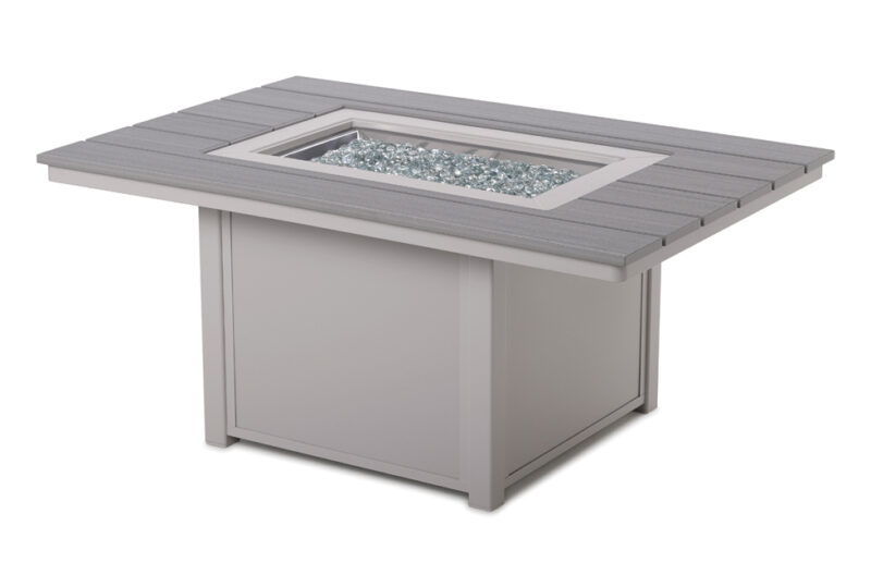 A modern square fire pit table with a grey composite build and a glass center filled with small blue crystals, isolated on a white background.