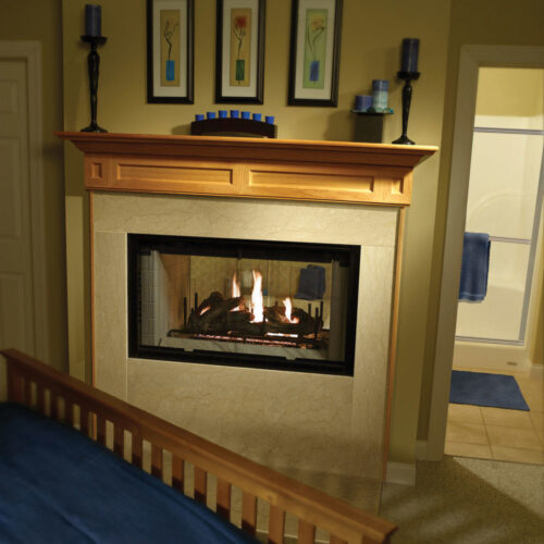 See-Through gas fireplace by Heatilator with wood-burning fireside gas logs in a traditional bedroom and bathroom