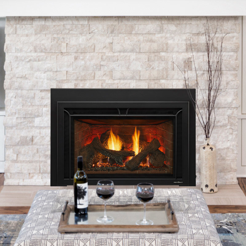Supreme Series gas fireplace insert by Heat & Glo in black with Iron Age front against white stone masonry hearth