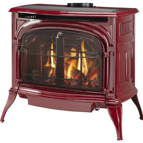 A red wood-burning stove with visible flames inside, standing on four sturdy legs, featuring a rounded body and a flat top, suitable for heating.