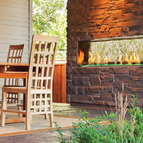 Lanai 48-inch see-through outdoor gas fireplace by Outdoor Lifestyles with dark brown stone hearth in modern patio