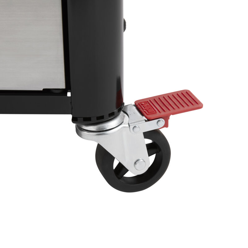 Close-up of a shiny metal caster wheel with a red brake pedal, attached to the base of a black and stainless steel Weber Genesis S-435 Four-Burner Natural Gas Grill, indicating mobility features