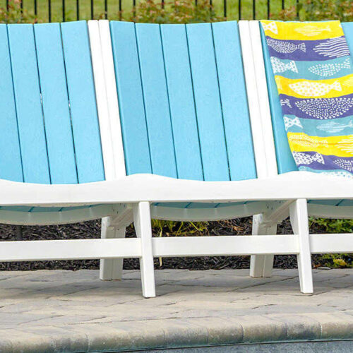 Chill Sofa in blue by Breezesta on an outdoor patio near a pool made from recycled poly in a variety of other colors