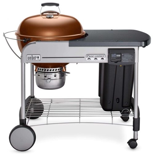 A Weber Performer Charcoal Grill with a copper lid, gray frame with a side table, integrated thermometer, and storage rack on wheels.