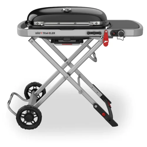 A Weber Traveler portable gas grill with a collapsible stand and large wheels, featuring an extended side table and a closed black lid.
