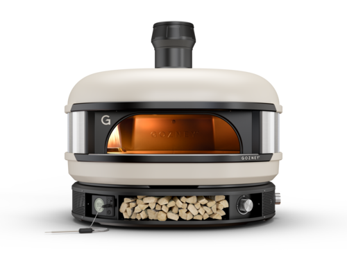 A modern, portable pizza oven with a metal body and visible fire chamber, branded "gozney." the oven has a stone baking floor and a chimney, set against a plain white background.