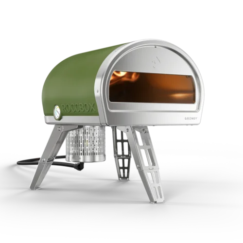 Portable Roccbox pizza oven with a green dome, visible flame inside, and stainless steel legs, isolated on a transparent background.