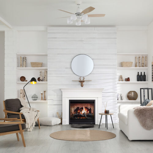 A cozy, modern living room featuring a SimpliFire Inception Electric Fireplace, wooden furniture, a plush sofa, and shelves with decorative items. A circular mirror hangs above the fireplace.