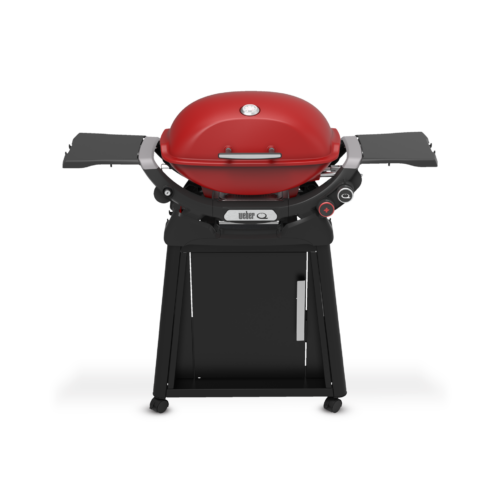 A modern red gas grill with side shelves and a closed lid, standing on a black cart with wheels and a cabinet for storage.