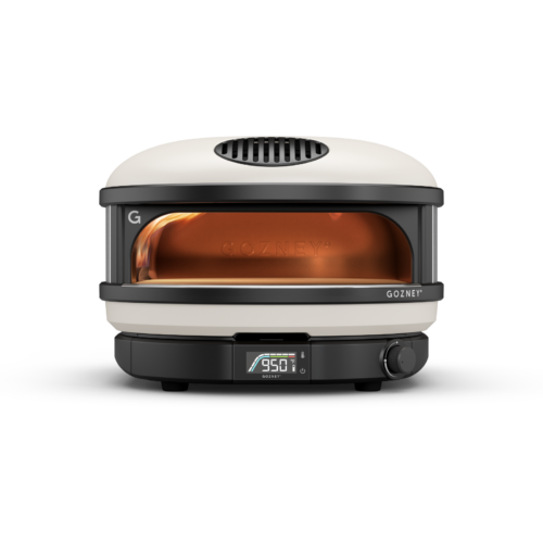 A modern gozney pizza oven in a sleek design, featuring a visible digital temperature display reading 950°f. the oven has a glass door revealing a glowing interior.
